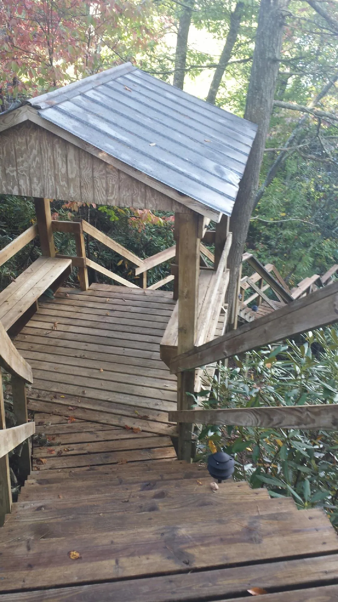 Metal roofed shelter over wooden steps on a wooded walkway — Skylight Repair & Installation work by our crew in Malvern